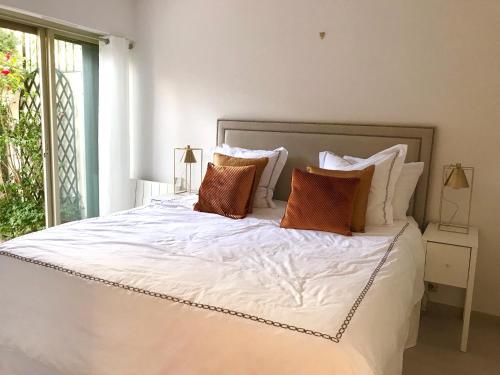 ein Schlafzimmer mit einem großen weißen Bett mit Kissen in der Unterkunft 19 Rue du Parc Alexandre III in Cannes