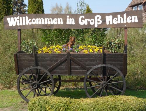 a sign with a dog sitting in a cart with flowers at Hotel Garni am Eckernweg in Celle