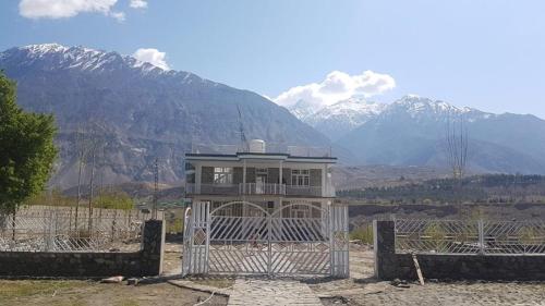 una casa detrás de una valla con montañas en el fondo en Junction Resort, en Jaglot