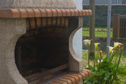 a stone bench with flowers in a garden at La Casina de Luarca in Luarca
