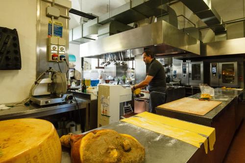 a man in a kitchen preparing food in a kitchen at Relais Fontevivo in Fontevivo