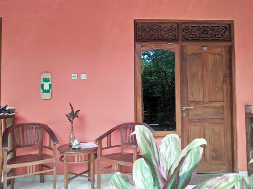 a room with two chairs and a table and a door at Made Roejas Homestay in Uluwatu