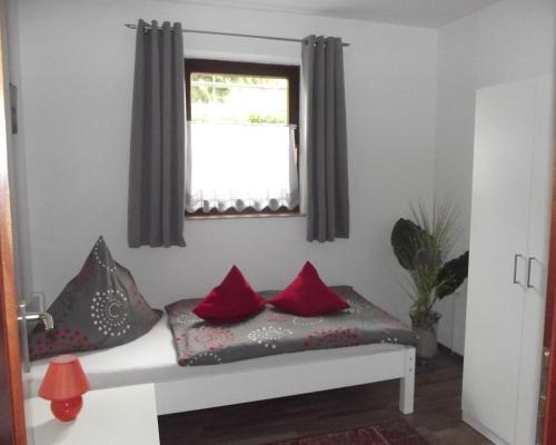 a room with a bed with red pillows and a window at Feworeinhard in Speyer