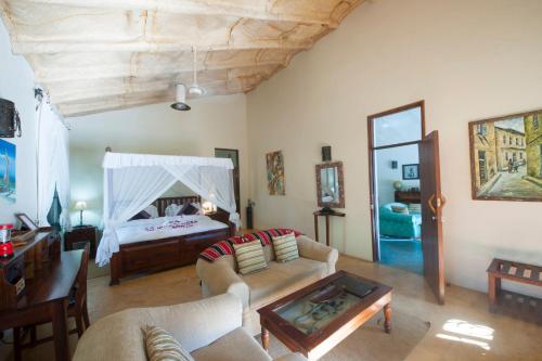 a living room with a bed and a couch and a table at Serenity on the Lake in Kalemera