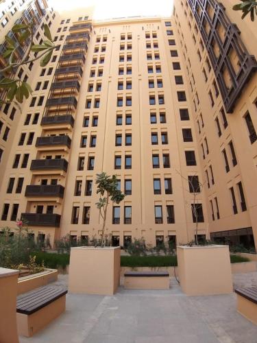 a large building with benches in front of it at Hyatt Place Dubai Wasl District Residences in Dubai