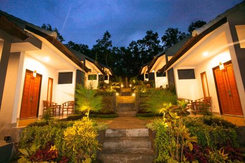 a courtyard of a house at night with a pathway at Singgahan Bungalow by ecommerceloka in Nusa Penida
