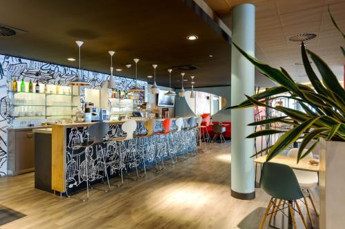a restaurant with a bar with stools at ibis Konstanz in Konstanz