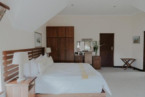 a bedroom with a large white bed and a staircase at Cana Vineyard Guesthouse in Paarl