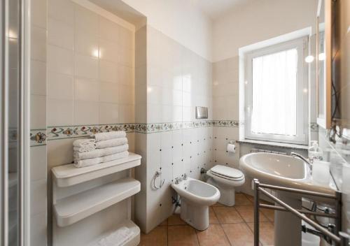 a white bathroom with a toilet and a sink at Fabiola B & B in Marino