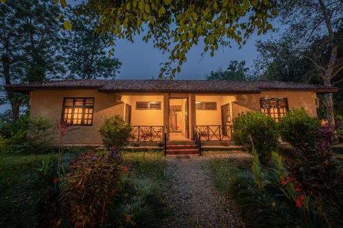 a small house with a porch and a door at Green Mansions Jungle Resort in Sauraha