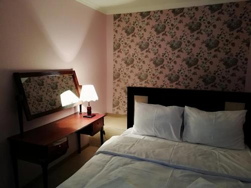 um quarto com uma cama e uma secretária com um espelho em Bella Apartment em Tbilisi