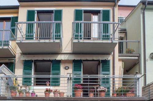 an apartment building with green shutters and potted plants at Le Terrazze di katia apartment in Riomaggiore