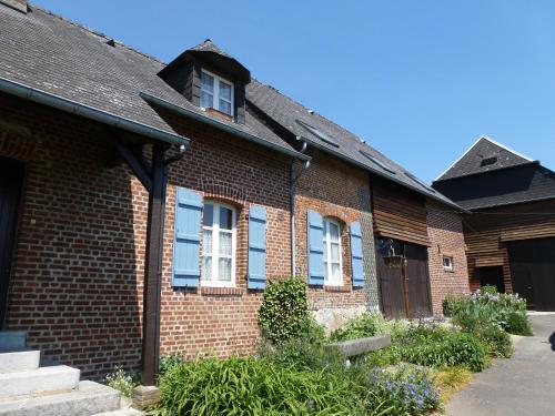 Una casa de ladrillo con persianas azules. en La Vannerie en Origny-en-Thiérache