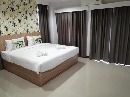 a bedroom with a large bed with white sheets at The Like hotel in Udon Thani