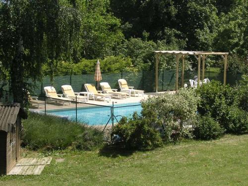 une piscine avec des chaises longues et un gazebo dans l'établissement au bonheur du cedre, à Saint-Lattier