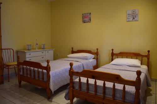 a bedroom with two beds and a dresser at AMISIANA HOUSE in Kavála