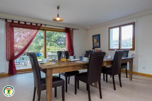 une salle à manger avec une table et des chaises en bois dans l'établissement au bonheur du cedre, à Saint-Lattier