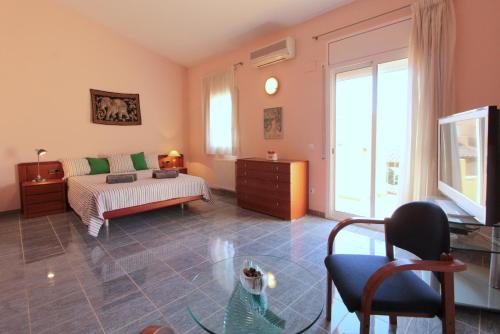 a bedroom with a bed and a tv in a room at LEON INMO Chalet Arenal - 15687 in Castelló d'Empúries