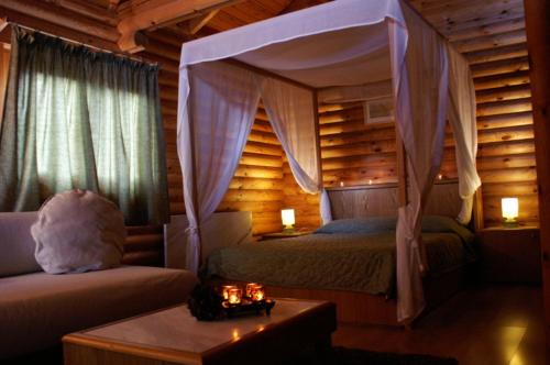 a bedroom with a bed and a couch and a table at Dionysus Village Resort in Mousthéni