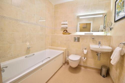 a bathroom with a tub and a toilet and a sink at The Coach and Horses in Worthing