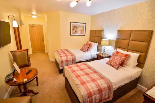 a hotel room with two beds and a table at The Coach and Horses in Worthing