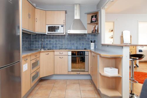 una cocina con armarios de madera y un aparato de acero inoxidable en Takvåning - Borgholm, en Borgholm