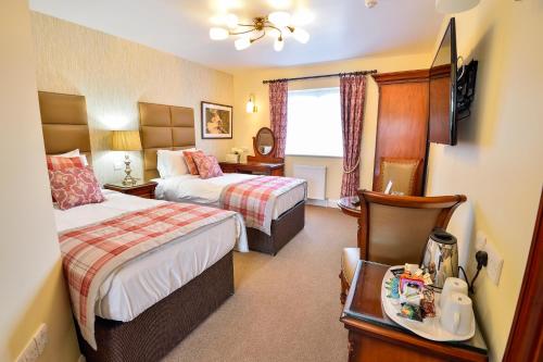 a hotel room with two beds and a table at The Coach and Horses in Worthing