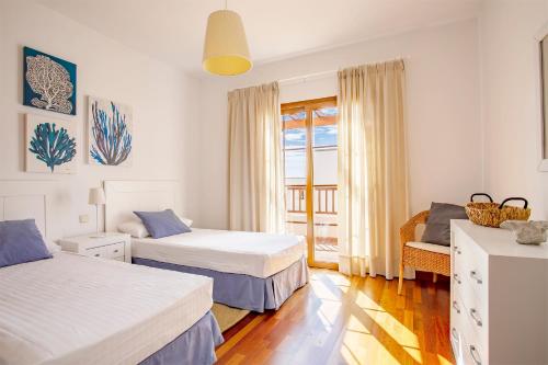 una habitación de hotel con 2 camas y una silla en Las Caletas Village, en Costa Teguise