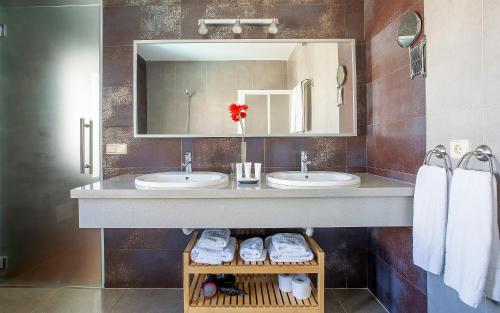 a bathroom with two sinks and a mirror and towels at Las Caletas Village in Costa Teguise
