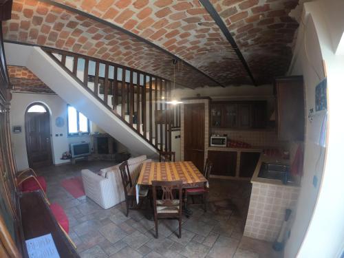 a kitchen and dining room with a table and a staircase at Tra... Monti E Vigne in La Morra