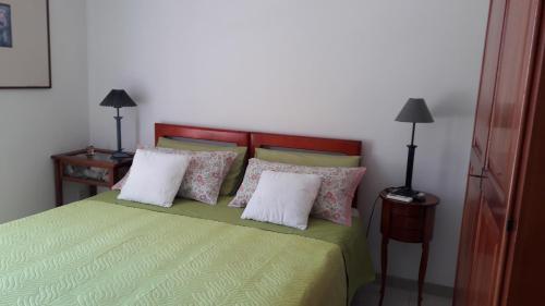 a bedroom with a green bed with two pillows at B&B Villa Ada in Formia