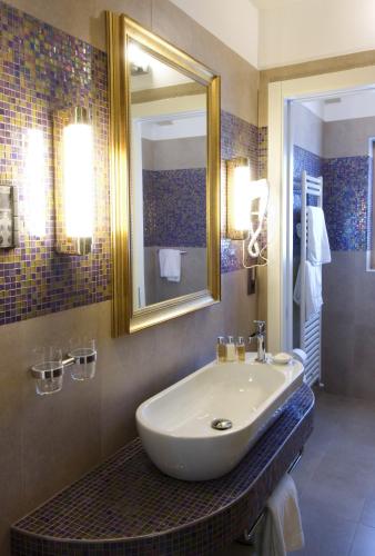 a bathroom with a sink and a mirror at Parc Hotel Flora S in Riva del Garda