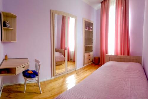 a bedroom with a bed and a desk and a mirror at Guest House Anuki in Sighnaghi