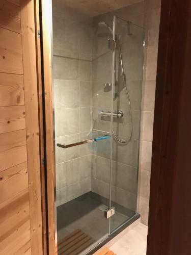 une douche avec une porte vitrée dans une salle de bain dans l'établissement Chalet Cyclamens, 65m2 plein centre - Jardin, WIFI & parking!, aux Carroz d'Arâches