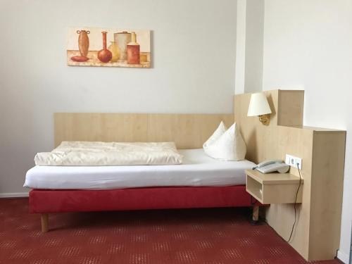 a bedroom with a bed with a phone on a table at Weinhotel Römerbad in Bad Salzuflen