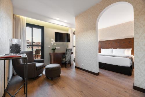 Habitación de hotel con cama y escritorio en Exe Agora Cáceres, en Cáceres