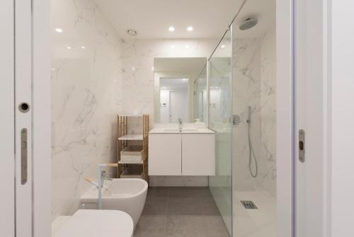 een badkamer met een wastafel, een toilet en een spiegel bij LovelyStay - Downtown Balcony Apartment with Free Parking in Porto