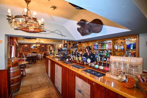 a bar in a pub with a man sitting at the counter at The Coach and Horses in Worthing