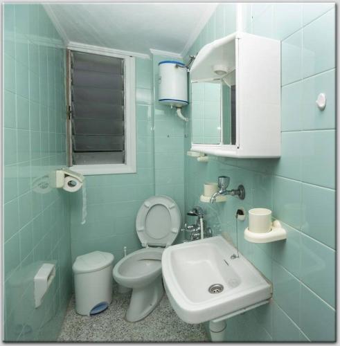 a blue bathroom with a toilet and a sink at Anni's apartments 50m from the beach in Agia Triada