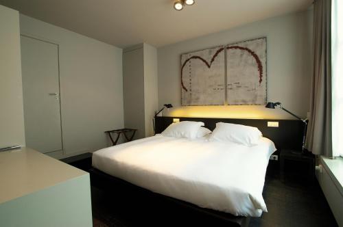 a bedroom with a large bed and a large mirror at Hotel Matelote in Antwerp