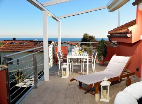 a patio with a table and chairs on a balcony at Villa Giovanna con terrazza panoramica, Jacuzzi e sauna in Loano