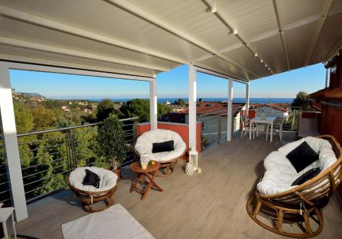 a balcony with chairs and a view of the ocean at Villa Giovanna con terrazza panoramica, Jacuzzi e sauna in Loano
