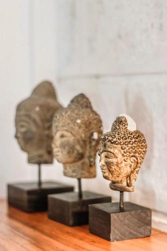 two statues of heads on display on a table at La Cabane in Jimbaran