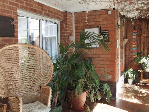 a patio with chairs and plants next to a brick wall at Elmdon Lodge in Birmingham