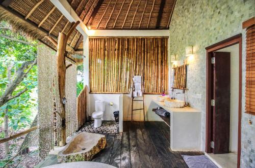 a bathroom with a toilet and a sink at La Cabane in Jimbaran