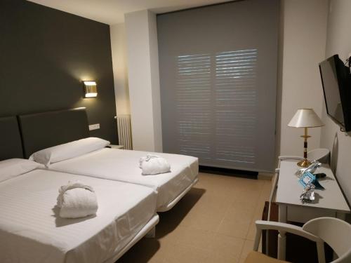 a bedroom with a bed with towels on it at Balneario de Ledesma in Vega de Tirados