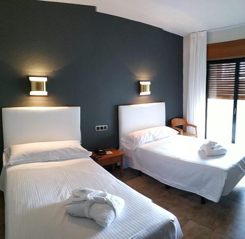 a bedroom with two beds with towels on them at Balneario de Ledesma in Vega de Tirados