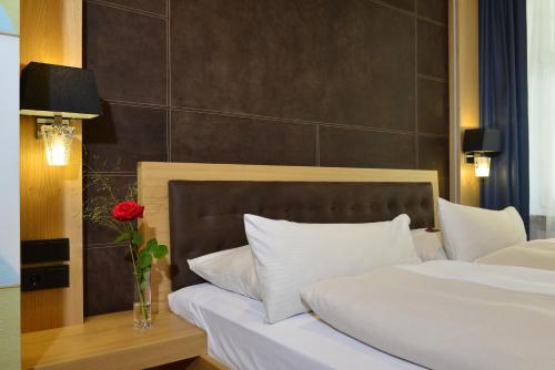 a hotel room with a large bed and a large mirror at Hotel Torbräu in Munich