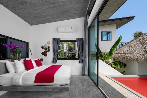 a bedroom with a large bed with red pillows at Pahili Pool Villas - SHA Plus in Ko Tao