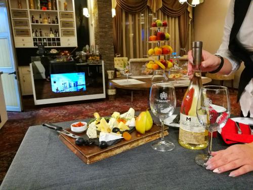 a table with a tray of food and a bottle of wine at Best Boutique Hotel in Stara Zagora